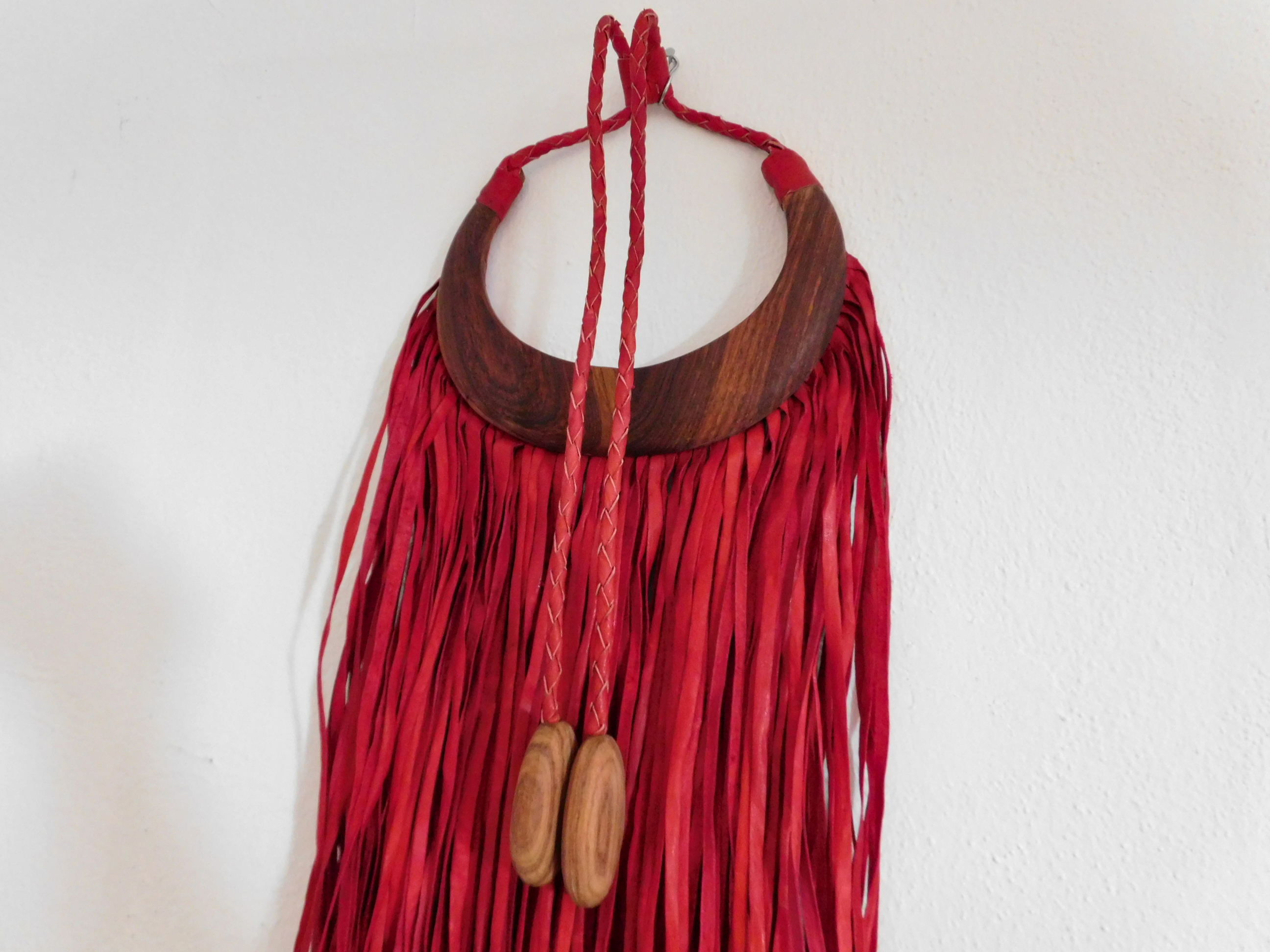 African decoration statement piece made of red leather fringes and wood
