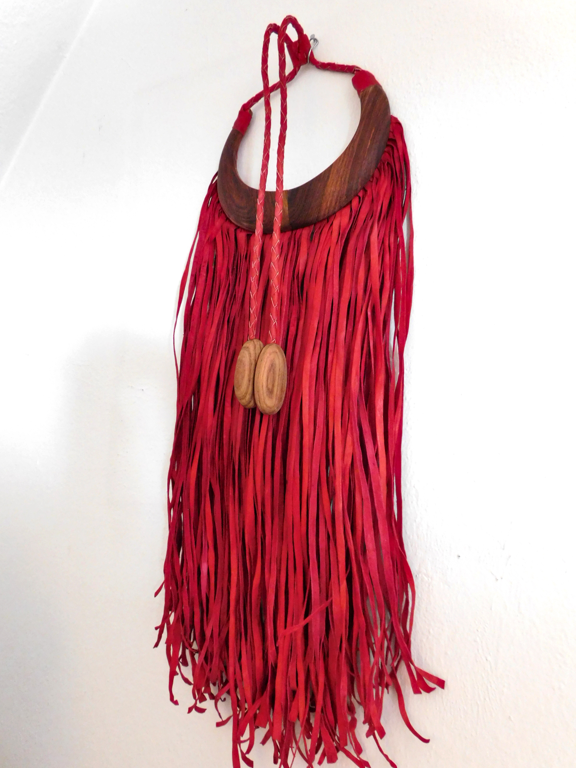 African decoration statement piece made of red leather fringes and wood